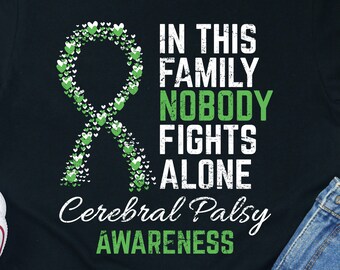 May include: Black t-shirt with a green ribbon made of hearts and the text "In this family nobody fights alone Cerebral Palsy Awareness".