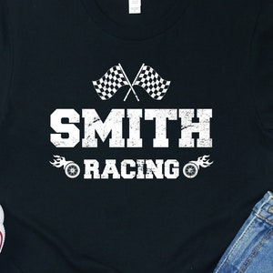 May include: Black t-shirt with a white graphic of chequered flags, the word "SMITH" in a bold font, and the words "RACING" with flames and tyre tracks on either side.