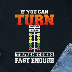 May include: Black t-shirt with a white graphic of a drag racing Christmas tree with the text "If you can turn you're not going fast enough".