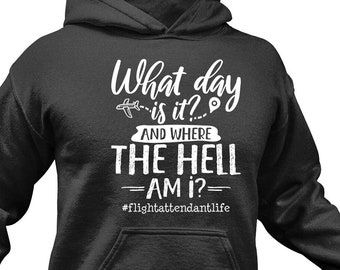 May include: A dark grey hoodie with a white graphic that says "What day is it? And where the hell am I? #flightattendantlife"
