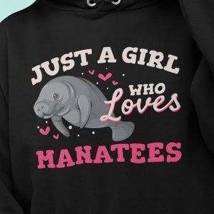 May include: Black hoodie with a pink graphic that says "Just a girl who loves manatees". The graphic also includes a cartoon manatee with pink hearts.
