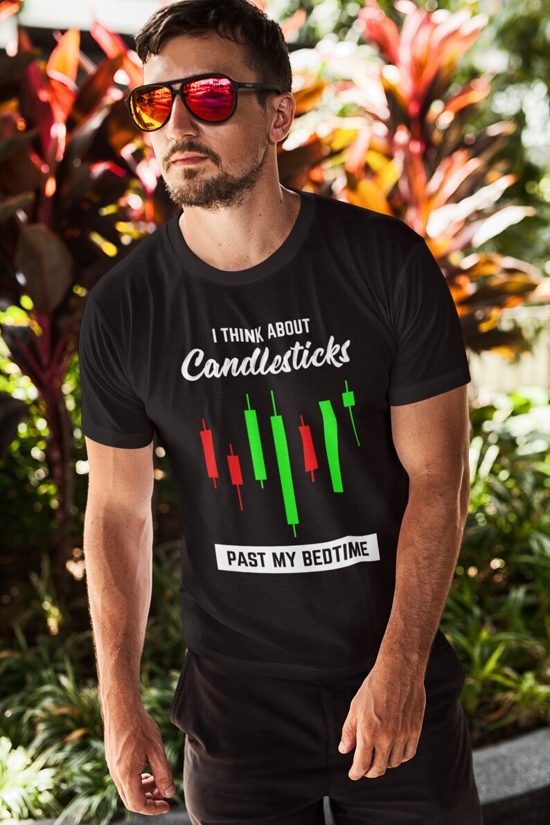 May include: Black t-shirt with a white graphic that says "I think about candlesticks past my bedtime". The graphic also includes a stylized candlestick chart with red and green bars.