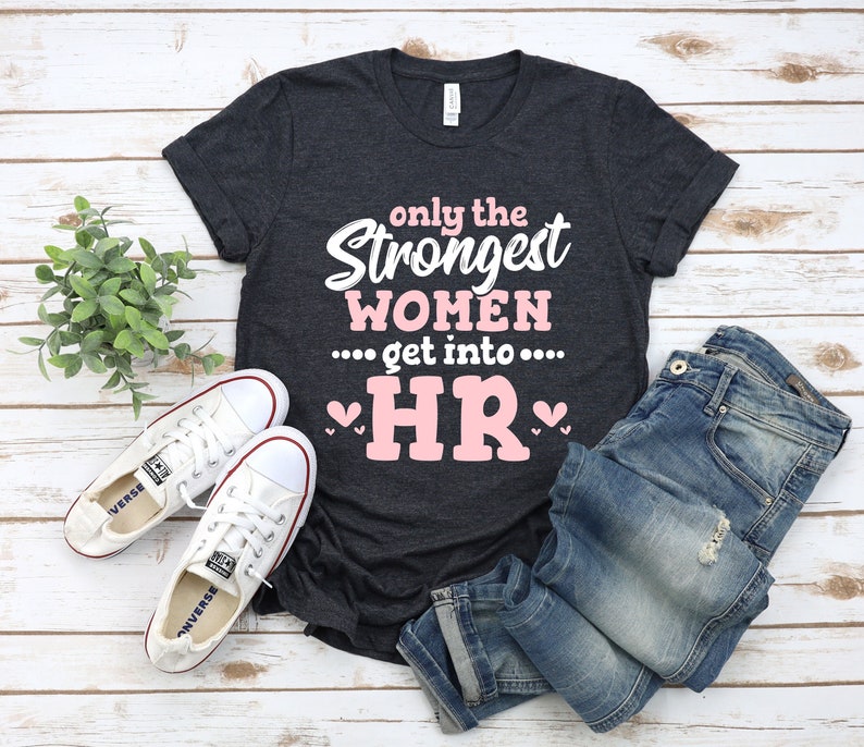 May include: A dark gray t-shirt with the text "only the strongest women... get into... HR" in white with a pink heart on each side of the text "HR".