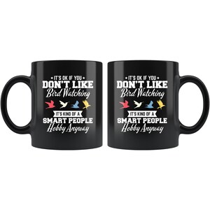 May include: Two black ceramic mugs with white text that reads "IT'S OK IF YOU DON'T LIKE Bird Watching. IT'S KIND OF A SMART PEOPLE Hobby Anyway." The design includes colorful bird illustrations.