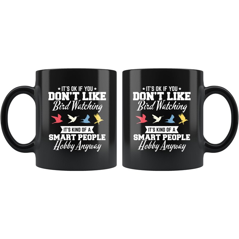 May include: Two black ceramic mugs with white text that reads "IT'S OK IF YOU DON'T LIKE Bird Watching. IT'S KIND OF A SMART PEOPLE Hobby Anyway." The design includes colorful bird illustrations.