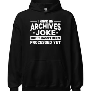 May include: Black hooded sweatshirt with white text that reads "I have an Archives Joke *But it hasn't been processed yet*"