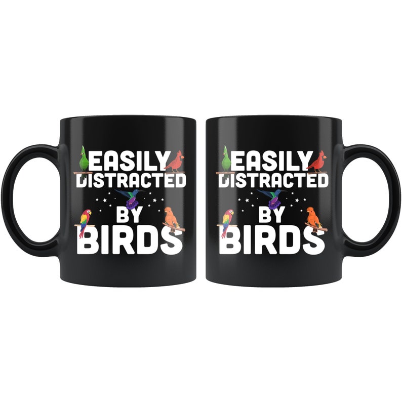 Puede incluir: Dos tazas de cer&aacute;mica negra con el texto "EASILY DISTRACTED BY BIRDS" en blanco. Las tazas presentan ilustraciones coloridas de varios p&aacute;jaros. Las tazas est&aacute;n dise&ntilde;adas para los amantes de las aves y son perfectas para caf&eacute; o t&eacute;.