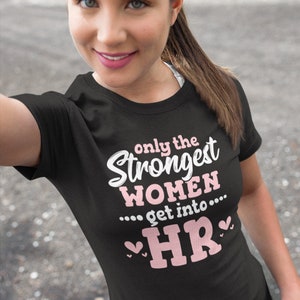 May include: Black t-shirt with pink text that reads "Only the Strongest Women... get into... HR" with pink hearts on either side of the text.