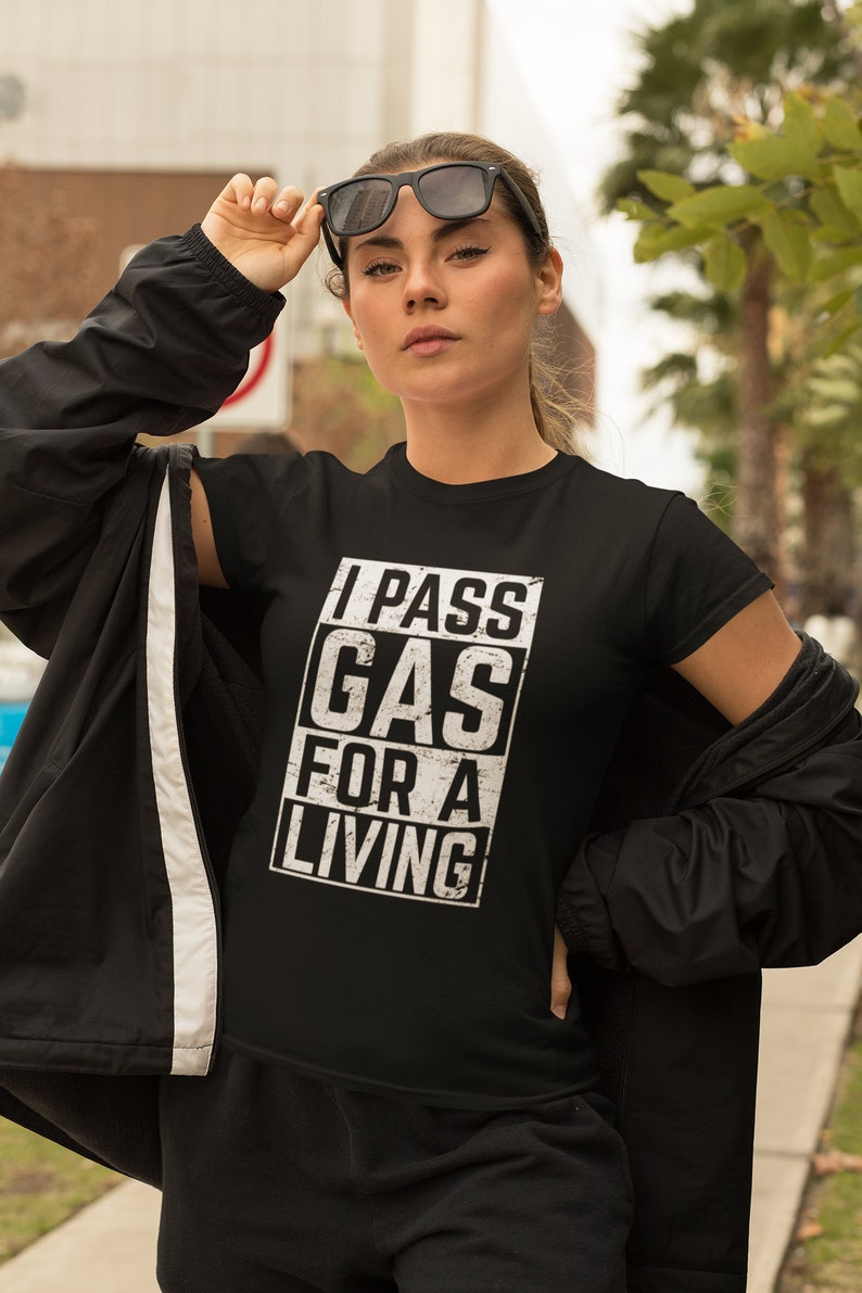May include: Black t-shirt with a white graphic that says "I PASS GAS FOR A LIVING".