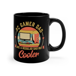 May include: Black ceramic coffee mug with a retro-style design featuring a computer, keyboard, and mouse. The text reads "PC Gamer Dad Like a Regular Dad But Cooler".