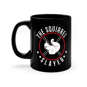 May include: Black ceramic coffee mug with a white graphic of a squirrel in a red target circle. The text "The Squirrel Slayer" is written around the target circle.