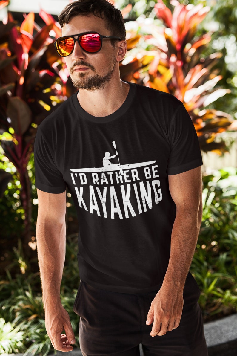 May include: Black t-shirt with a white graphic of a person kayaking and the text "I'd rather be kayaking".