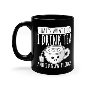 May include: Black ceramic mug with a white design that says "That's what I do I drink tea and I know things". The design also includes a cartoon teacup with a smiling face.