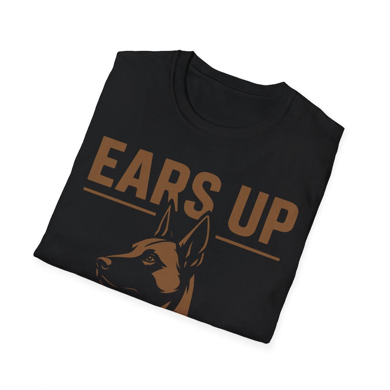 May include: Black t-shirt with the phrase "EARS UP" in brown block letters. A brown graphic of a dog's head and ears is below the text. The shirt is folded.