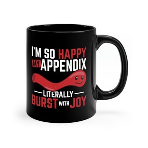 May include: Black coffee mug with a white design that says "I'm so happy my appendix literally burst with joy". The design also includes a red cartoon appendix with a smiley face.