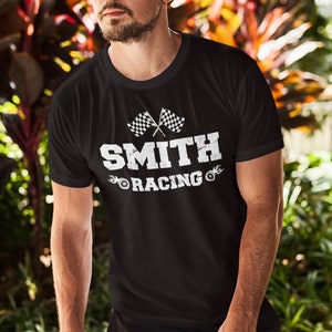 May include: Black t-shirt with a white graphic design featuring a chequered flag, the word "SMITH", and the words "RACING" with stylised tyre tracks.