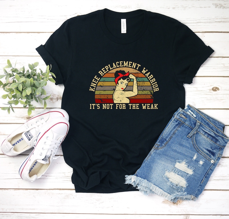 May include: Black t-shirt with a vintage-style graphic of a woman with a red bandana and the text "Knee Replacement Warrior. It's not for the weak."