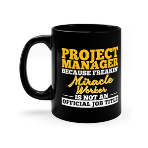 May include: Black ceramic coffee mug with a yellow design that reads "Project Manager because freakin' Miracle Worker is not an official job title."