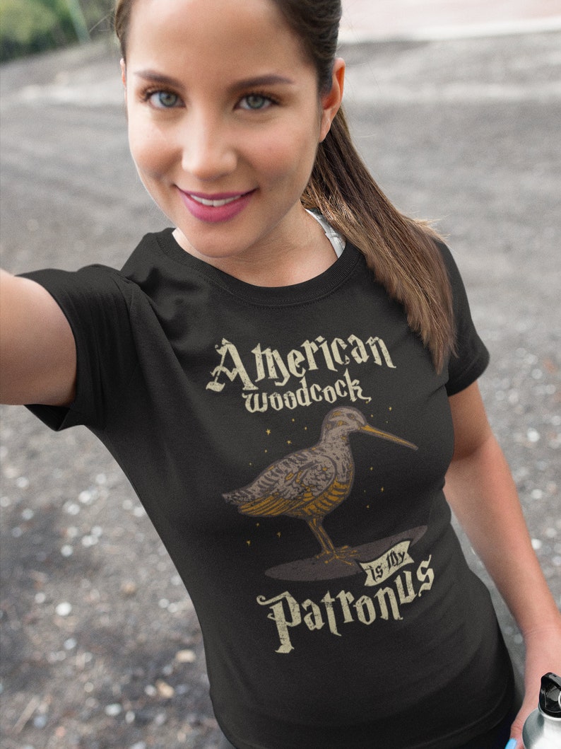 May include: A black t-shirt with a graphic of an American Woodcock bird and the text "American Woodcock is my Patronus".