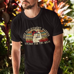 May include: A black t-shirt with a vintage-style graphic of a woman flexing her bicep. The graphic says "Knee Replacement Warrior" and "It's not for the weak".