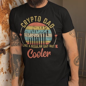 May include: A black t-shirt with a vintage-style graphic that says "Crypto Dad" with a stylized chart and the text "Like a regular dad but cooler".