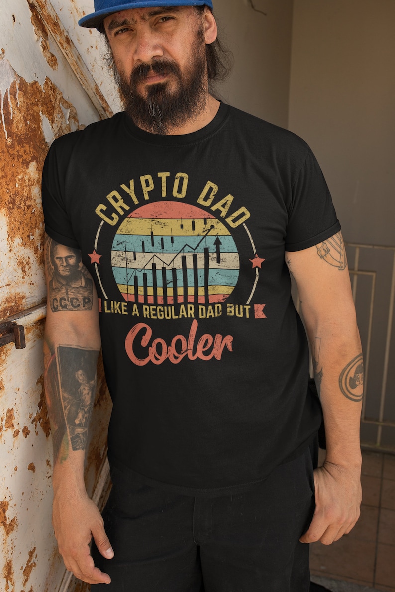 May include: A black t-shirt with a vintage-style graphic that says "Crypto Dad" with a stylized chart and the text "Like a regular dad but cooler".