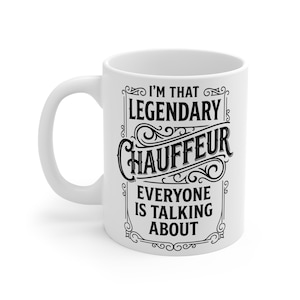 May include: A white ceramic mug with a black handle and the text "But First, Coffee" in a bold, black font. The mug is set against a blurred background, suggesting a cozy setting.
