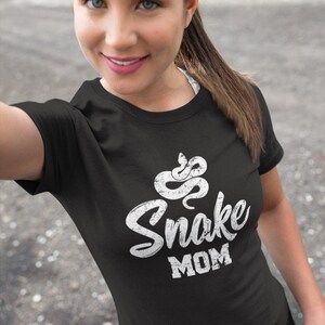 May include: A black t-shirt with a white snake graphic and the text "Snake Mom" in a distressed font.