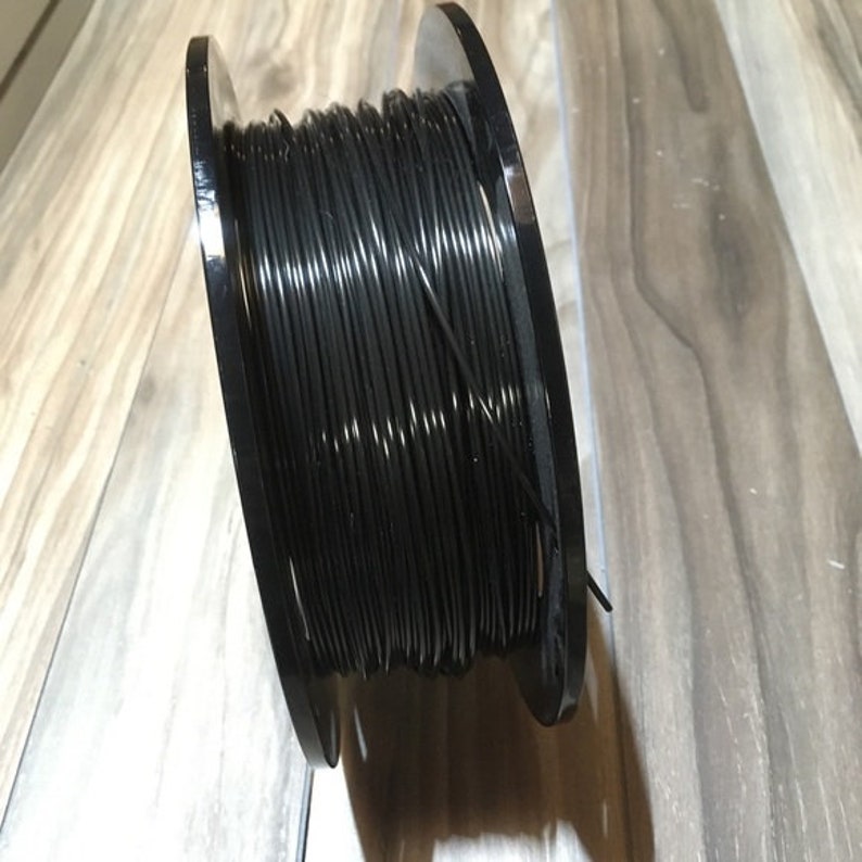 May include: A spool of black filament for 3D printing.