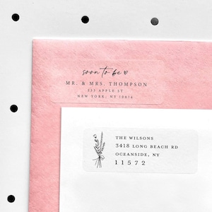 May include: A close-up of two white address labels on a pink envelope and white paper. The top label reads "soon to be" and the address of Mr. & Mrs. Thompson. The bottom label has the address of The Wilsons.
