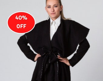 Può includere: Un cappotto nero avvolgente con cintura a nodo e un orlo asimmetrico. Il cappotto è in saldo con il 40% di sconto.