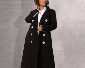 May include: A black double-breasted coat with white buttons. The coat is long and has a classic style.