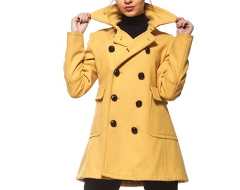 May include: A woman wearing a yellow double-breasted peacoat with black buttons and black pants.