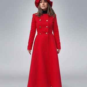 May include: A long red coat with a double breasted closure and a matching red hat. The coat has a fitted bodice and a flared skirt.