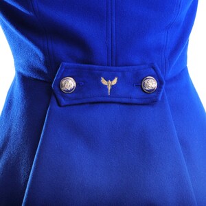 May include: A royal blue coat with a gold embroidered design and two gold buttons.