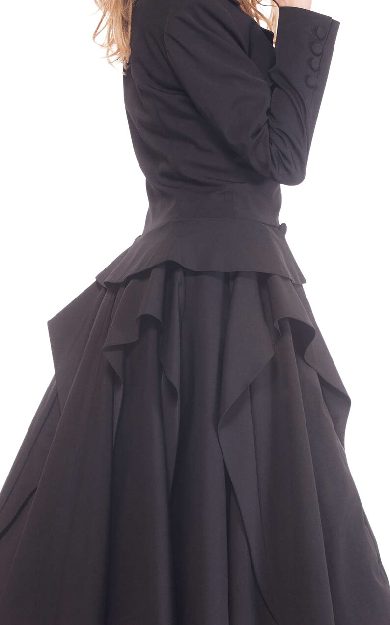 May include: A black dress with a ruffled skirt and a fitted bodice. The dress has a long, flowing skirt with multiple layers of ruffles.