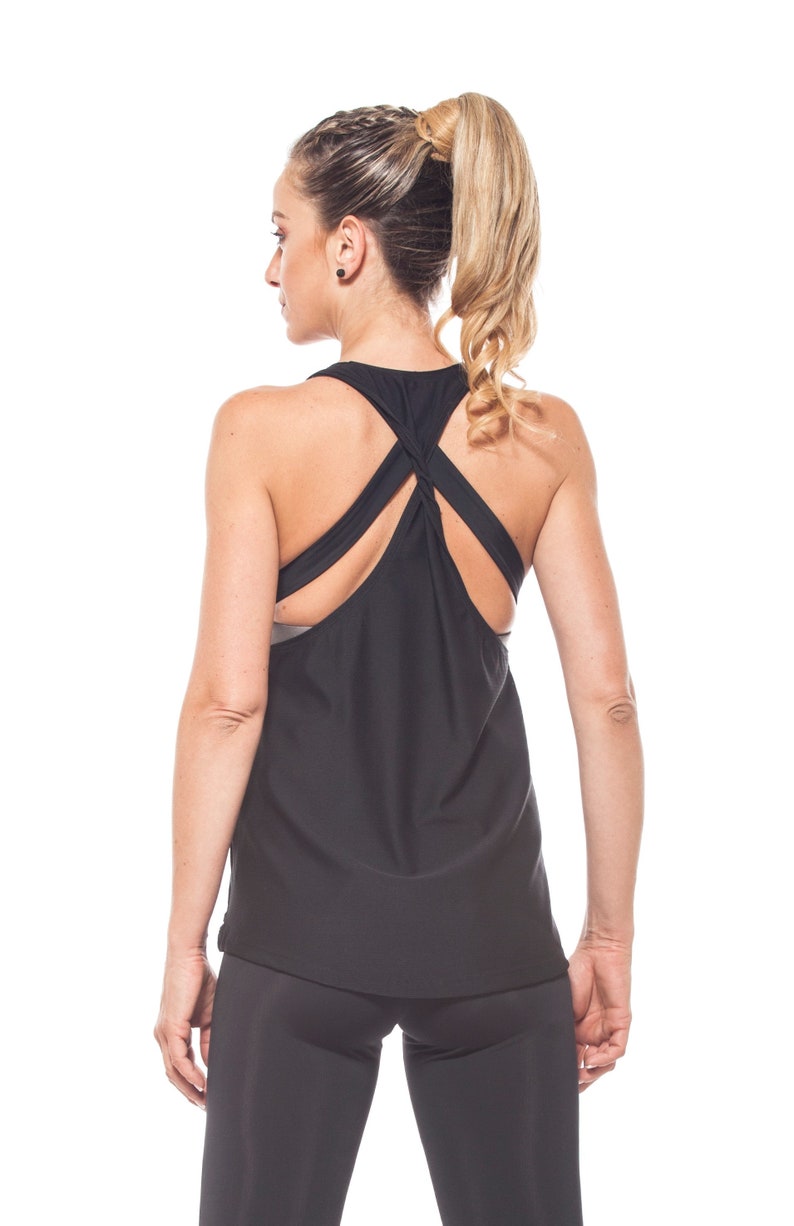 May include: A black tank top with a criss-cross back design. The tank top is made of a lightweight, breathable fabric and is perfect for working out or running errands.