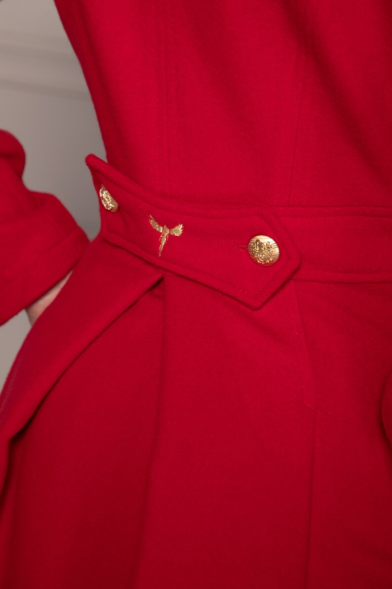 May include: A red coat with a gold button and a gold embroidered dragonfly on the waist.