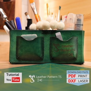 Könnte beinhalten: Grüner Lederorganizer mit zwei Taschen und einem Etikett mit der Aufschrift "Leather Pattern TS". Der Organizer ist gefüllt mit verschiedenen Kunstbedarfsartikeln, darunter Pinsel, Marker und ein kleines Behälter mit Farbe.