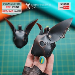 May include: Two black leather bunny masks with long ears. One mask is in focus, showing detailed stitching and metal accents. The image includes text: "DOWNLOAD FILES PDF PRINT DXF/SVG LASER" and "Leather Pattern TS" and "Tutorial You Tube".