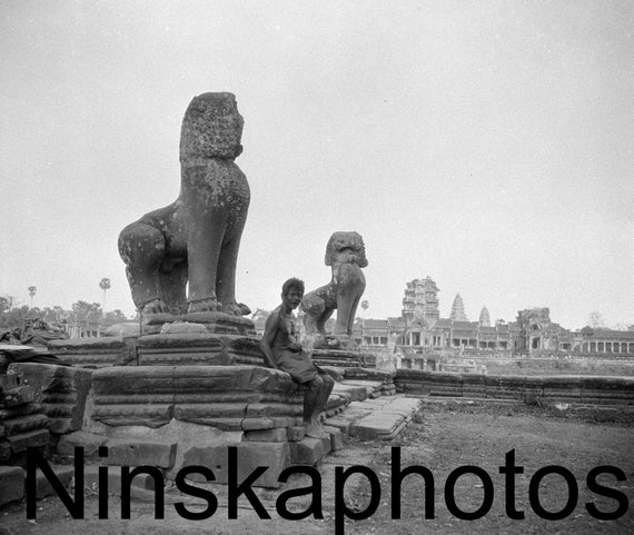 Angkor Wat, Cambodia - Man sitting on a statue at the entrance by J. Dearden Holmes, 1920s antique photo reprint