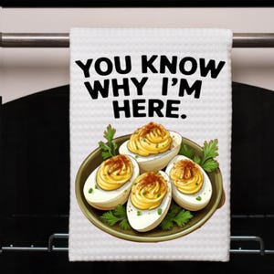 May include: White kitchen towel with the text "YOU KNOW WHY I'M HERE." The towel features an illustration of deviled eggs on a green plate, garnished with parsley. The eggs are topped with a yellow filling and paprika.