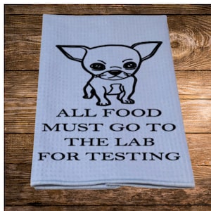 May include: A blue kitchen towel with a black and white illustration of a chihuahua and the text "All food must go to the lab for testing."