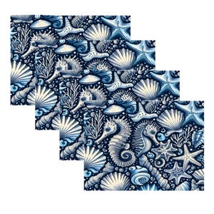 Op de afbeelding: Drie vierkante decoratieve panelen met een herhalend patroon van schelpen, zeesterren, zeepaardjes en koraal in tinten blauw en wit tegen een donkerblauwe achtergrond. De panelen zijn in een gelaagd, verspringend ontwerp gerangschikt.