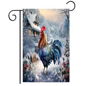 May include: A garden flag featuring a vibrant rooster in a snowy winter scene. The rooster has blue, brown, and red plumage, standing in front of a snow-covered house and trees. The flag is attached to a black metal stand.