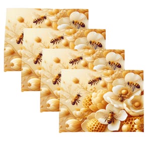 May include: A stack of four rectangular decorative placemats. Each placemat features a detailed illustration of bees, flowers, and honeycomb in shades of yellow, cream, and white. The design has a soft, artistic style.