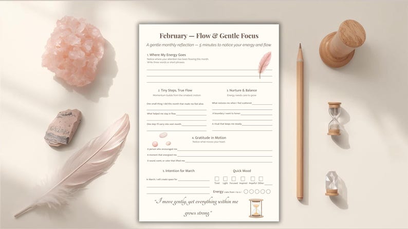 May include: A beige monthly reflection sheet titled "February - Flow & Gentle Focus" with prompts for self-reflection. The image includes a pencil, a wooden pushpin, a small hourglass, a feather, and crystals.