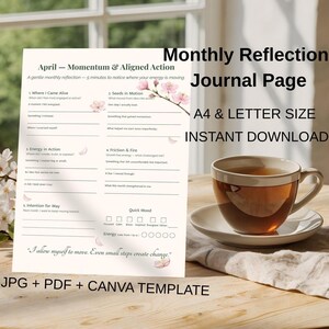 May include: A Monthly Reflection Journal Page with the text "April - Momentum & Aligned Action" and "A4 & Letter Size Instant Download". A cup of tea sits on a saucer next to the journal. The journal has prompts and space for writing.