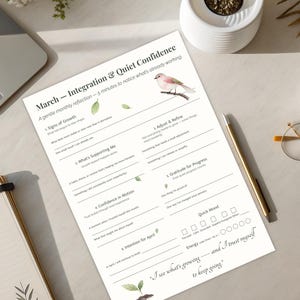 May include: A workspace scene featuring a laptop, notebook, and a printed worksheet titled "March - Integration & Quiet Confidence." The worksheet has prompts for reflection, a bird illustration, and the quote "I see what's growing - and I trust myself to keep going."