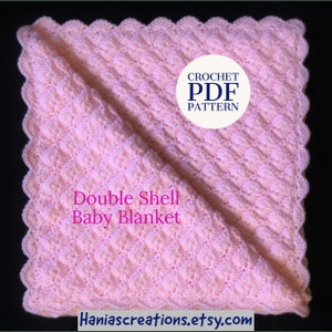 Könnte beinhalten: Eine rosa gehäkelte Babydecke mit einem gewellten Rand. Die Decke ist in der Hälfte gefaltet und der Text "Double Shell Baby Blanket" ist sichtbar. Der Text "CROCHET PDF PATTERN" ist ebenfalls in einem weißen Kreis sichtbar.